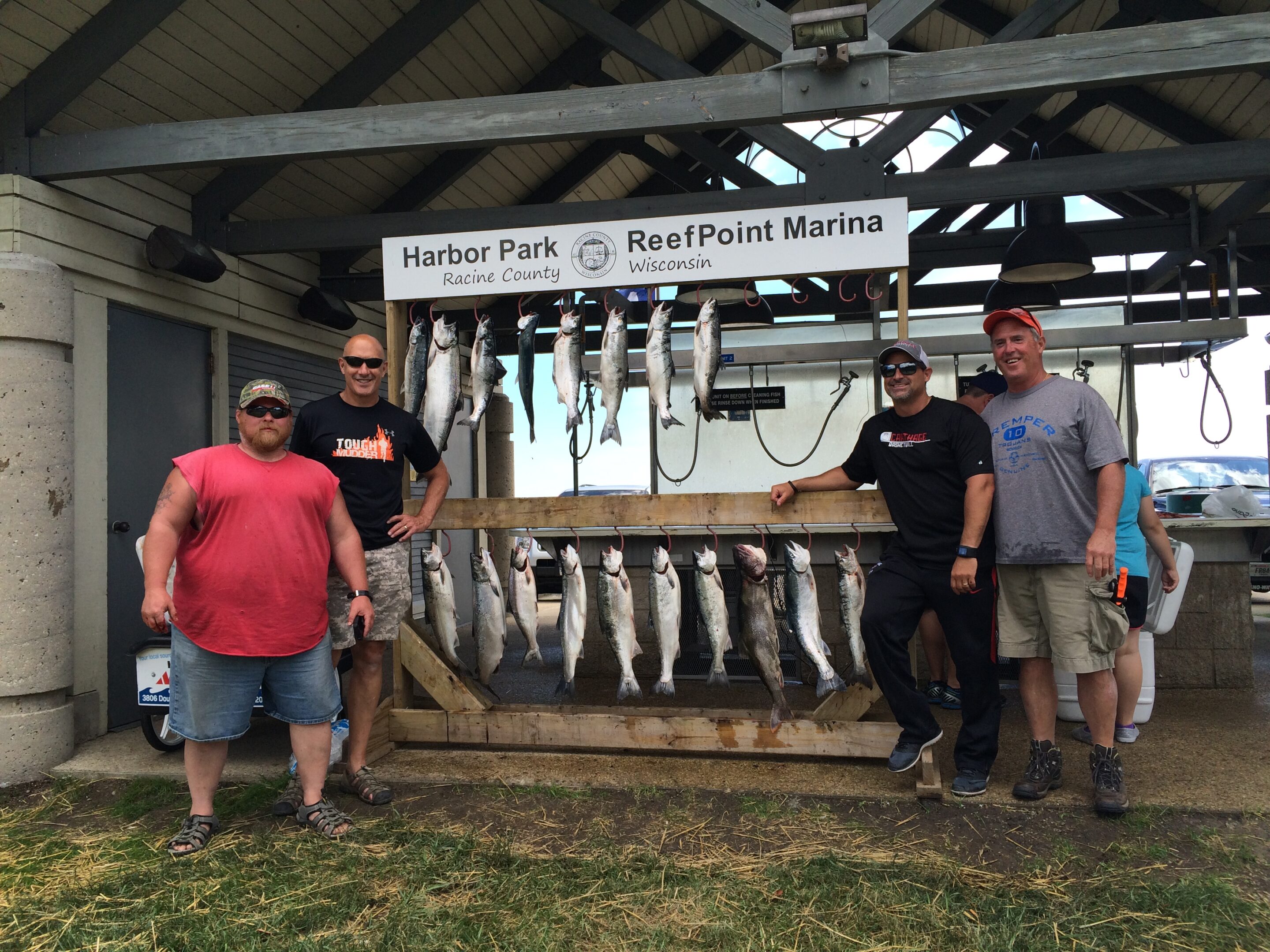 Four men standing with their catch of fish at Hunter Park Reel Point Marina.