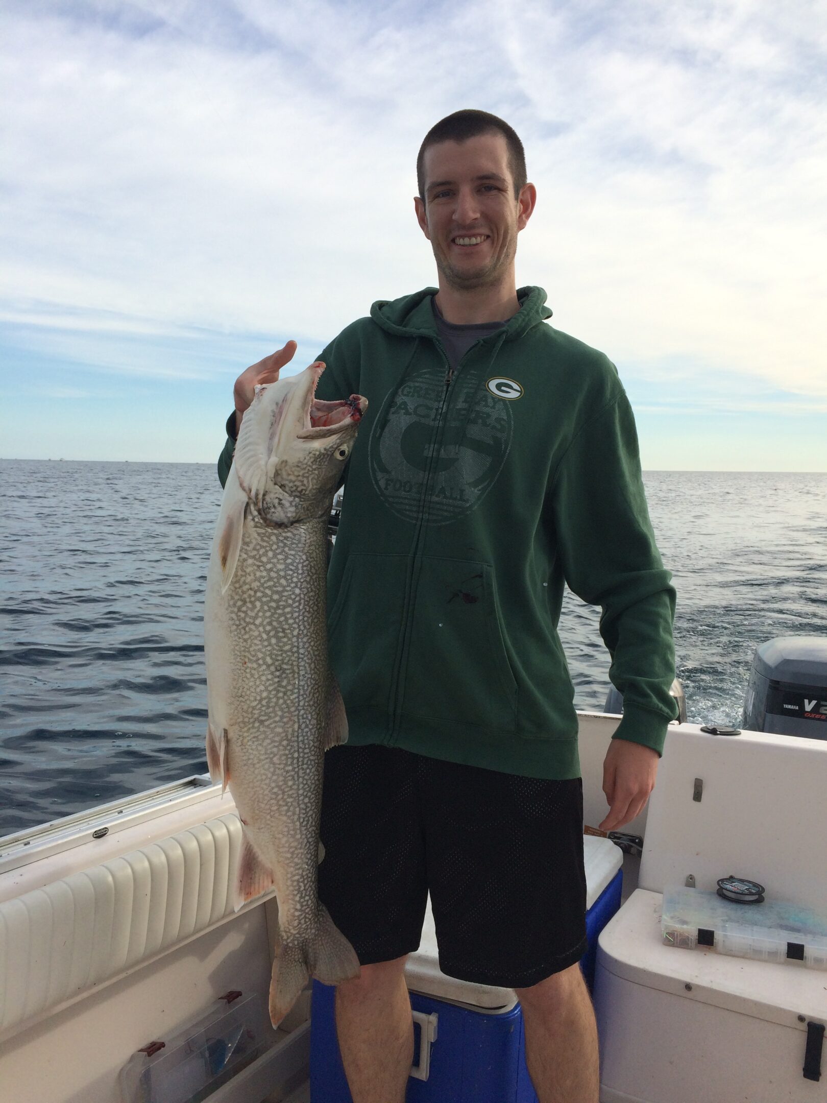 Man holding a large fish on a boat.