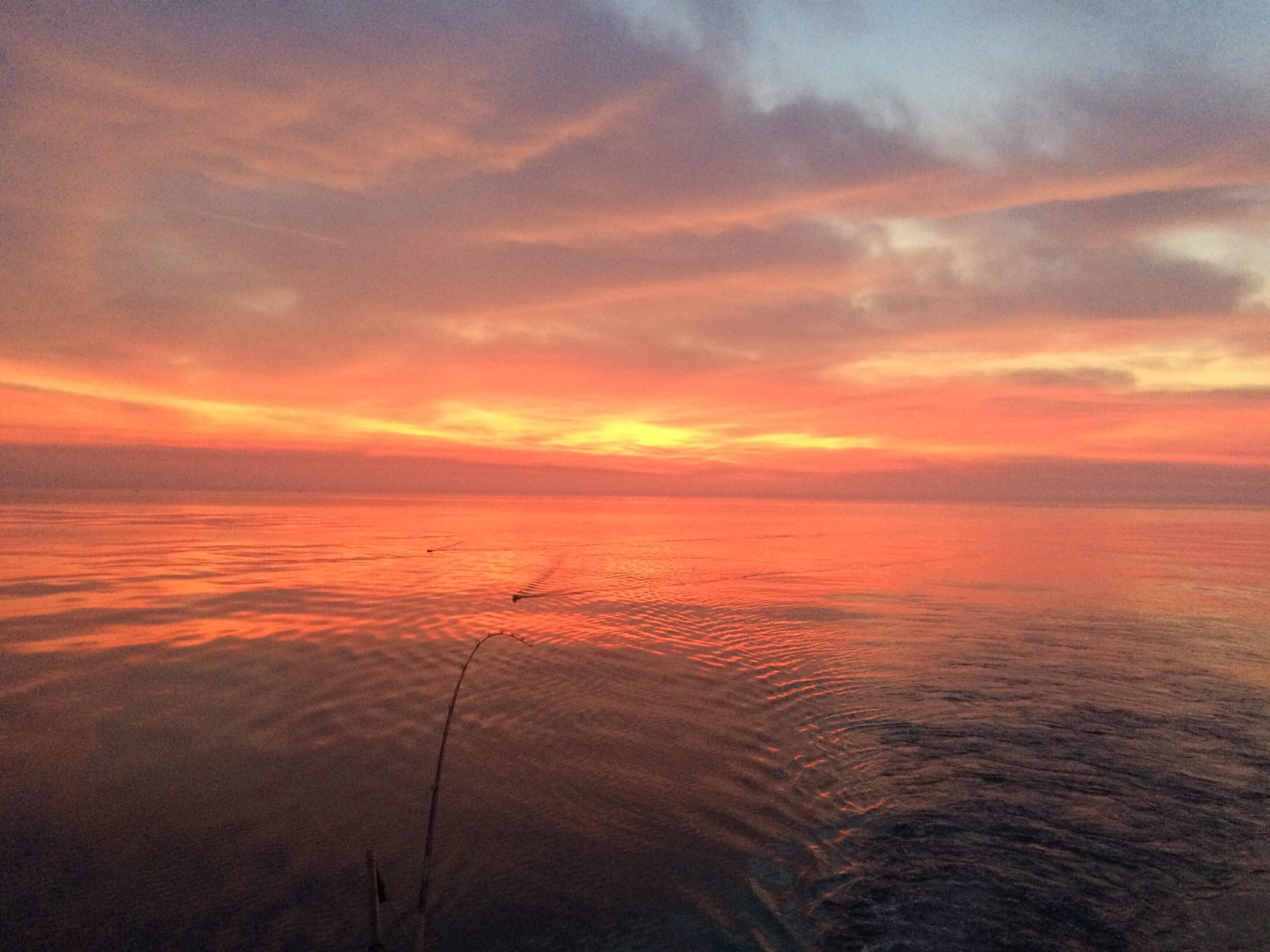 A vibrant sunset over calm ocean waters.