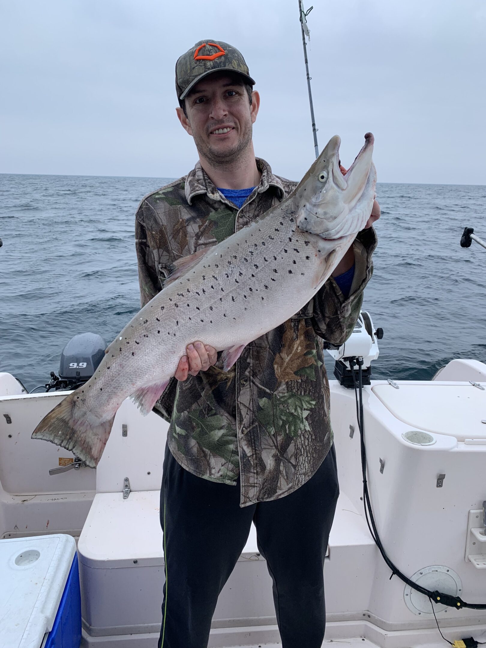 A person on a boat holding a large fish.