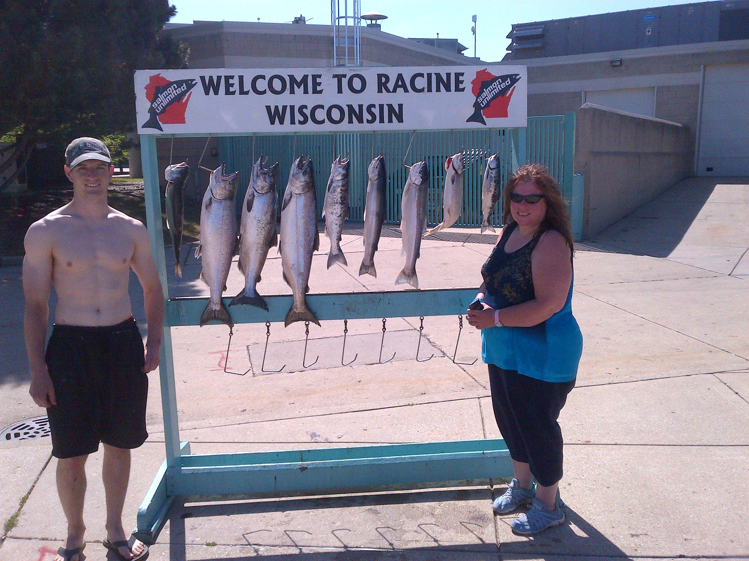 A woman posing next to a display of seven caught fish in Wisconsin.