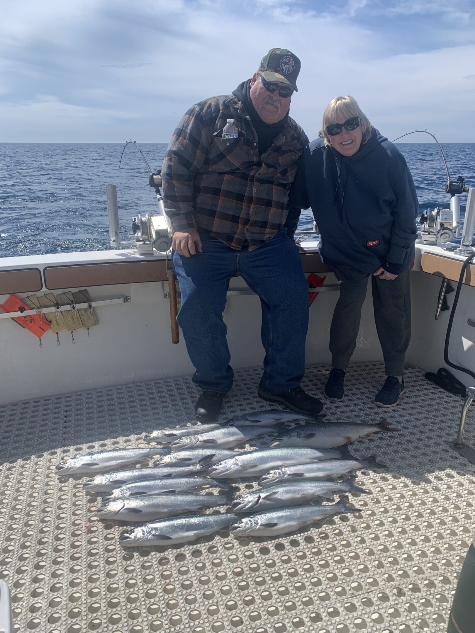 Two people on a boat with a catch of fish laid out.