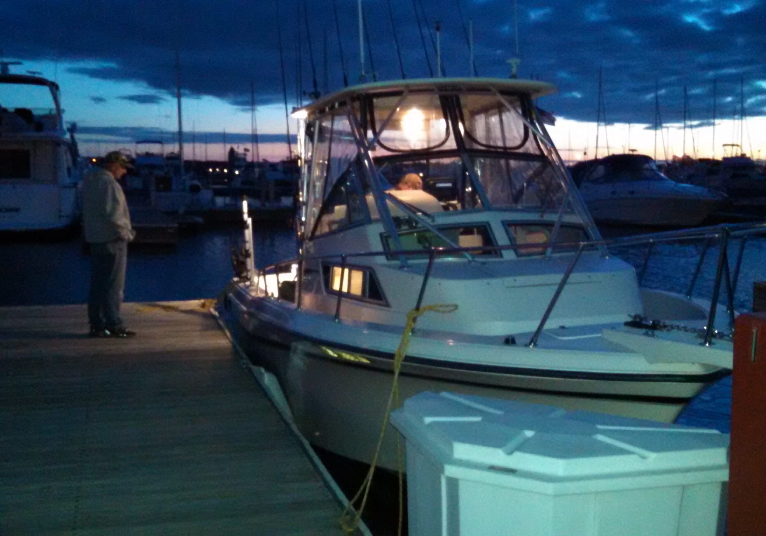 A boat docked at a marina during twilight.